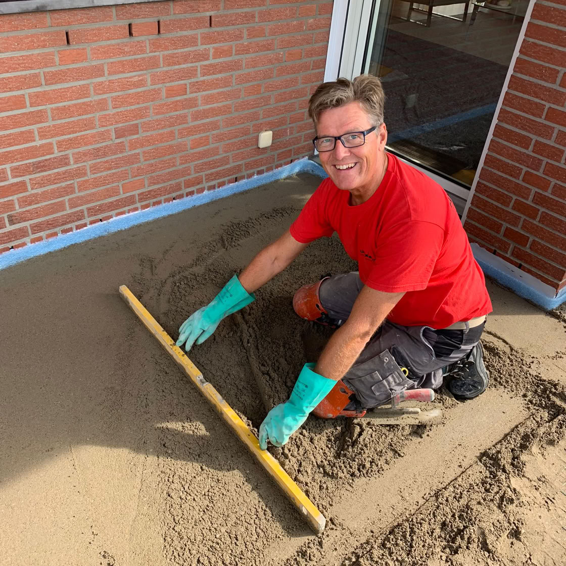 Nahaufnahme einer teilweise gefliesten Wand in einem Baustellenbereich, die unvollst&auml;ndige Renovierungsarbeiten zeigt.